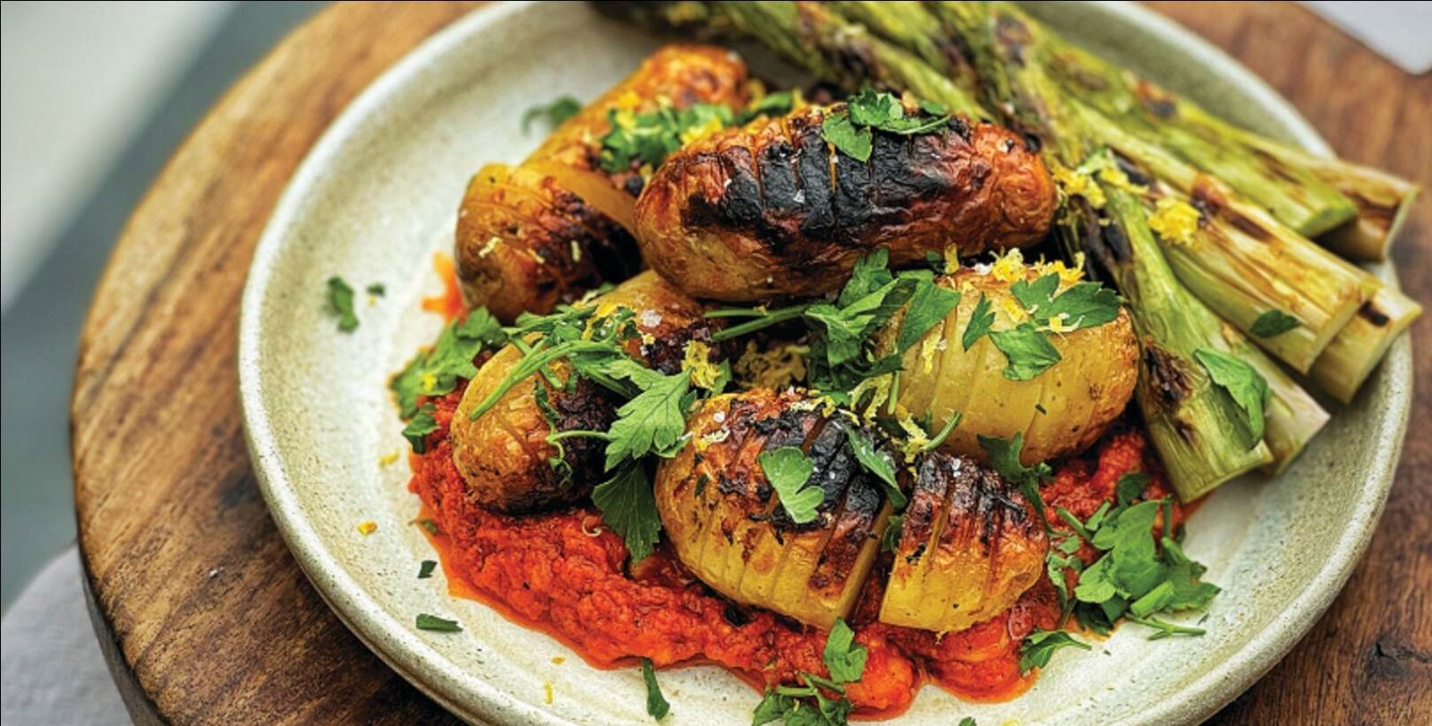 Hasselback potatoes with grilled asparagus and romesco sauce